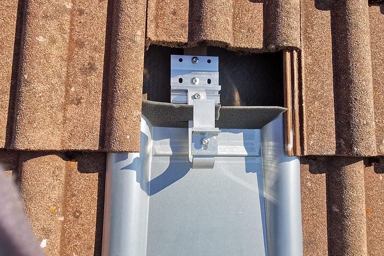 Nahaufnahme eines Dachhakens mit Dichtprofil auf einem Blechziegel
